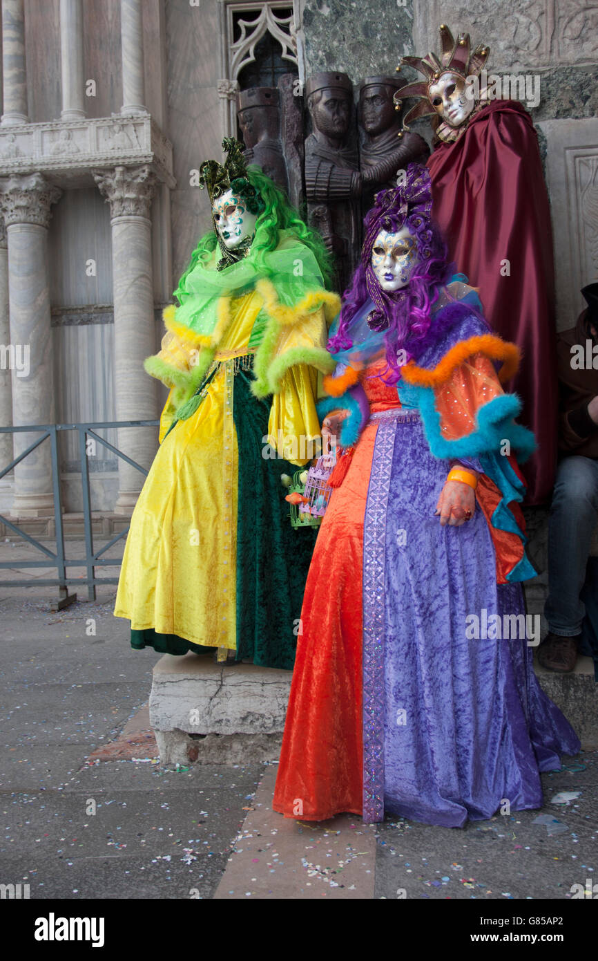 Gruppo di maschere in posa in piazza San Marco durante il tradizionale carnevale veneziano. Foto Stock