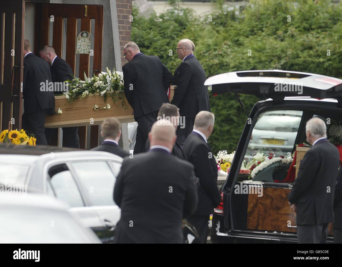 La bara Charles Patrick Evans, 78 morti nell'attacco terroristico di Sousse in Tunisia insieme al figlio Adrian Evans, 49 anni, e al nipote Joel Richards, 19, viene portata nella chiesa cattolica romana della Santa Croce a West Bromwich per il loro servizio funerario. Foto Stock