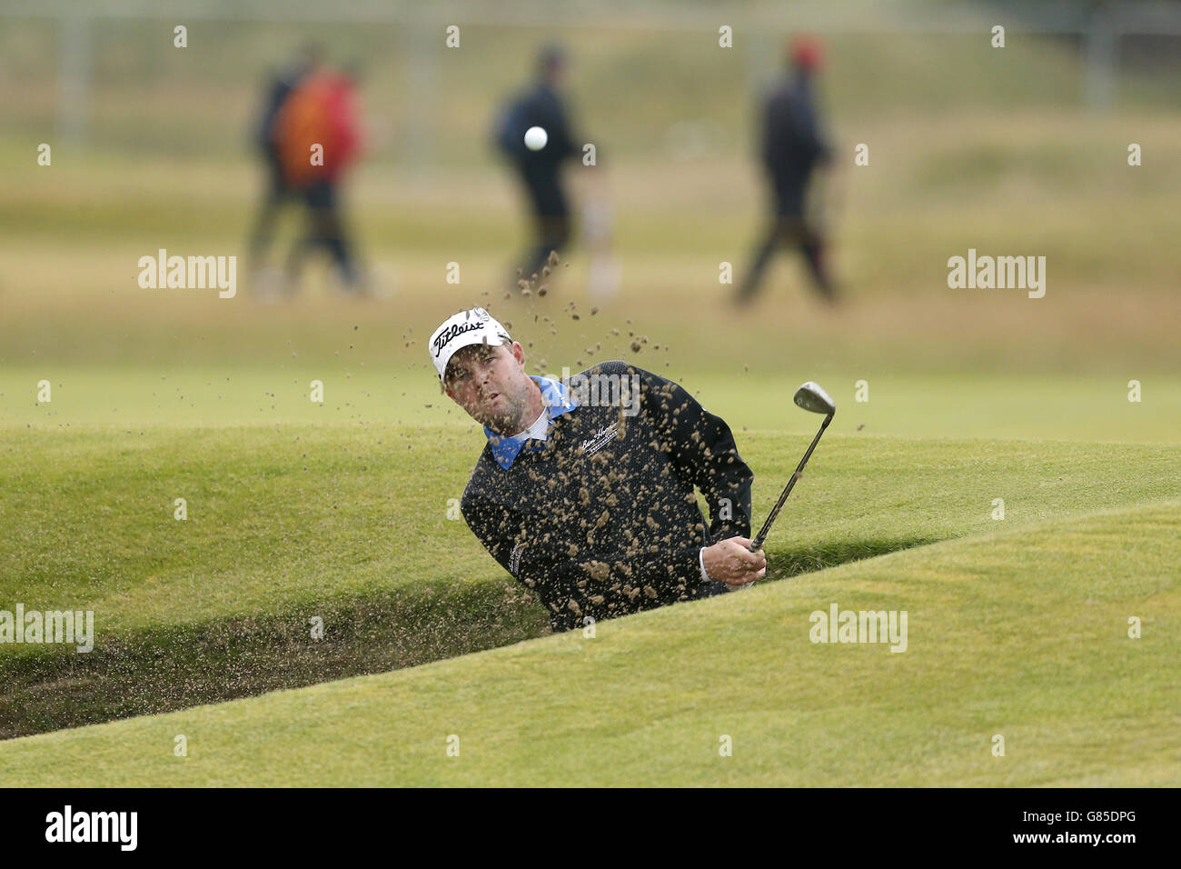 Marc Leishman, australiano, gioca fuori da un bunker nella 17a buca durante il quinto giorno dell'Open Championship 2015 a St Andrews, Fife. Foto Stock
