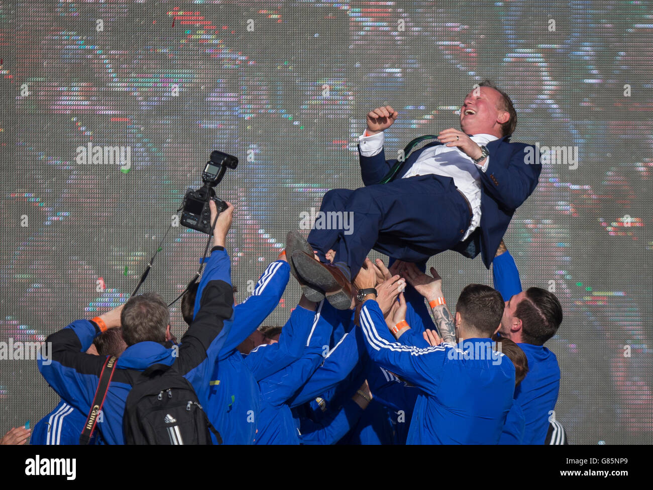 Irlanda del Nord i giocatori sollevare manager Michael O'Neill in aria come si celebra con i tifosi delle squadre successo nel 2016 Campionato Euro in Francia mentre al Titanic Fanzone, Belfast. Foto Stock