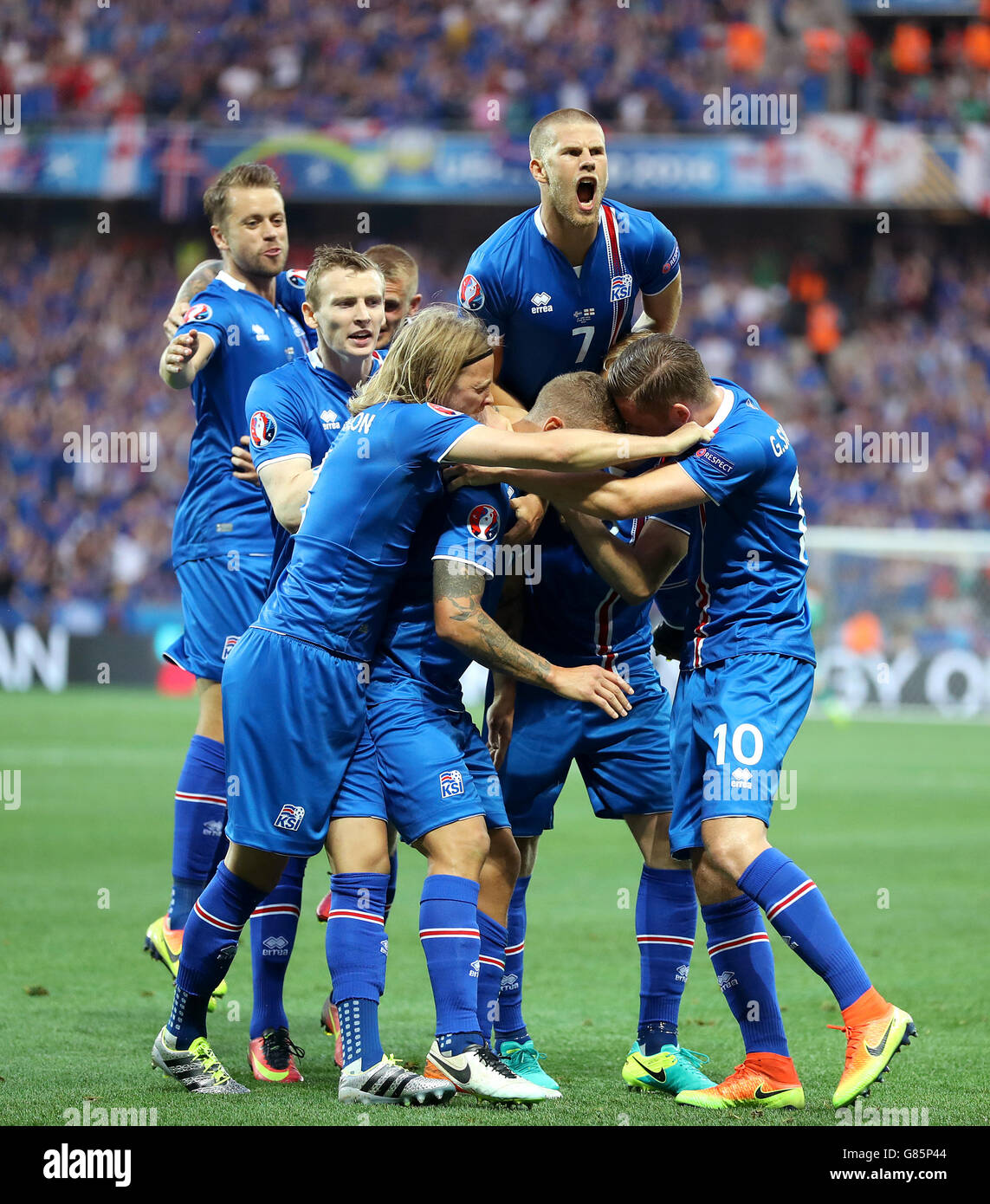 L'islanda Ragnar Sigurdsson (centro, parzialmente nascosti) viene assaliti dai suoi compagni di squadra come egli celebra il suo punteggio lato del primo obiettivo durante il Round di 16 corrispondono a Stade de Nice, Nice, Francia. Foto Stock