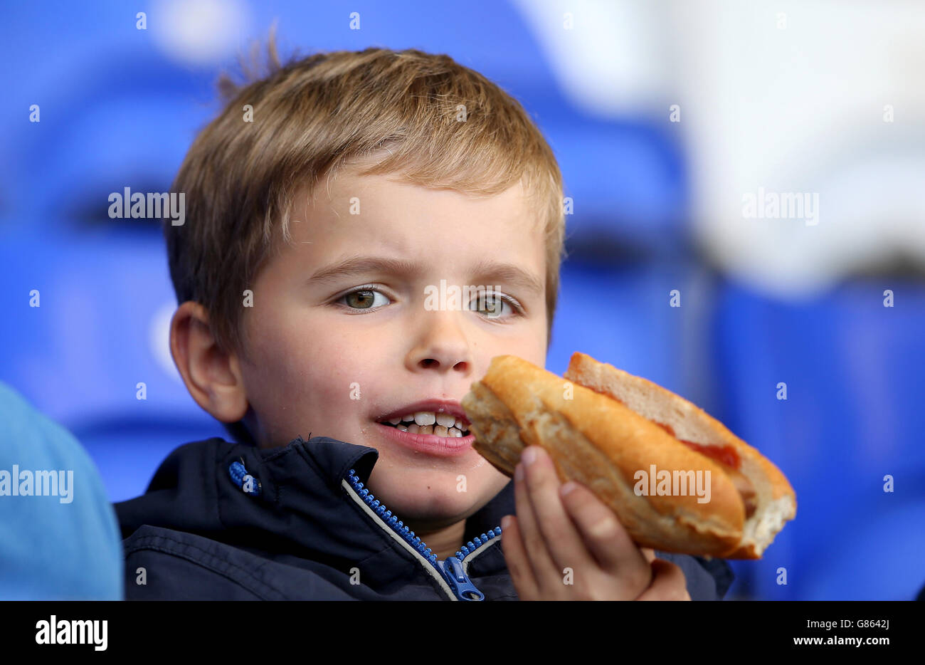 Un giovane fan di Birmingham si diverte a mangiare nelle tribune Foto Stock