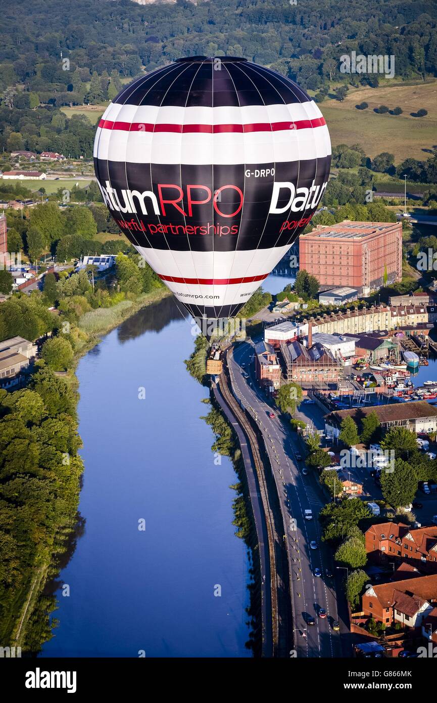 Una mongolfiera vola sopra Bristol in fuga verso la Bristol International Balloon Fiesta, che vedrà centinaia di mongolfiere che si riuniscono sui cieli di Bristol e Somerset per quattro giorni di feste di mongolfiera e di volo. Foto Stock