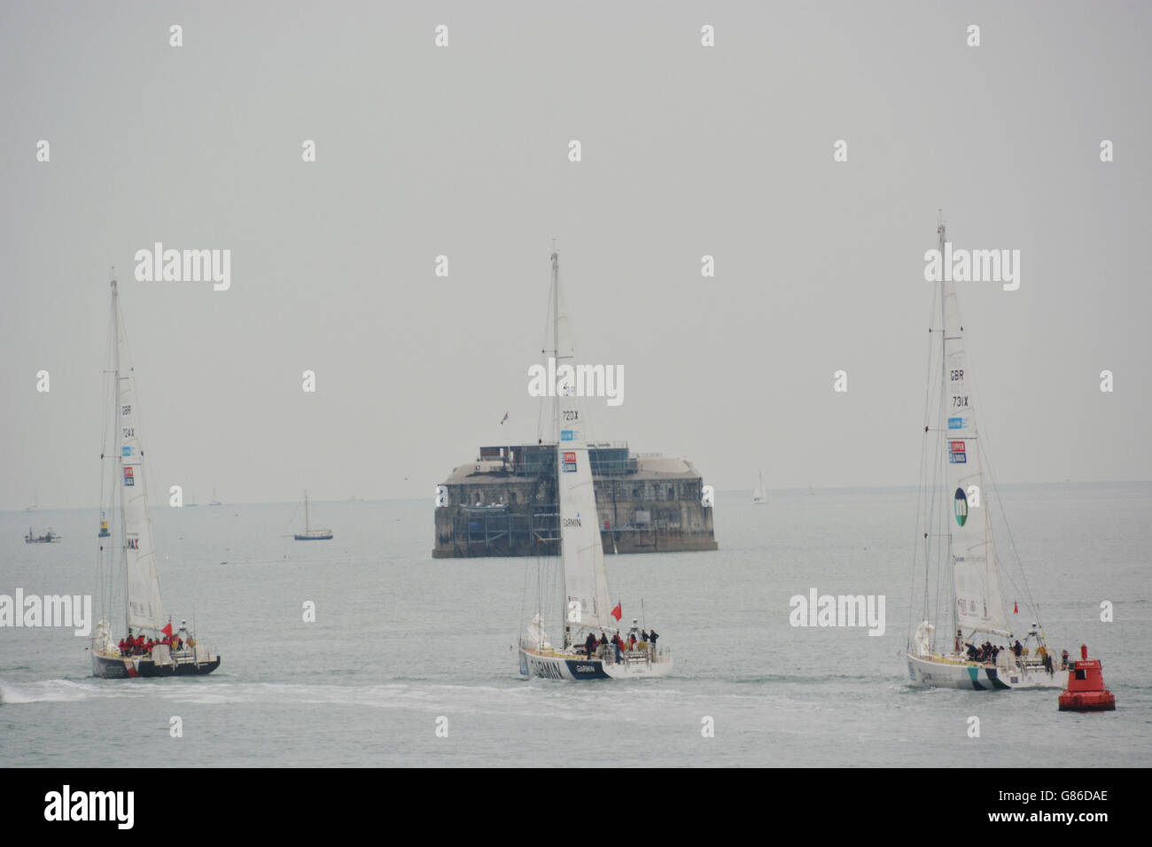 Una flotta di yacht Clipper da corsa sull'oceano sfilerà dal porto di Portsmouth e passeranno Spitbank Fort nel Solent mentre si dirigeranno a Londra per l'inizio della corsa degli yacht Clipper Round the World. Foto Stock