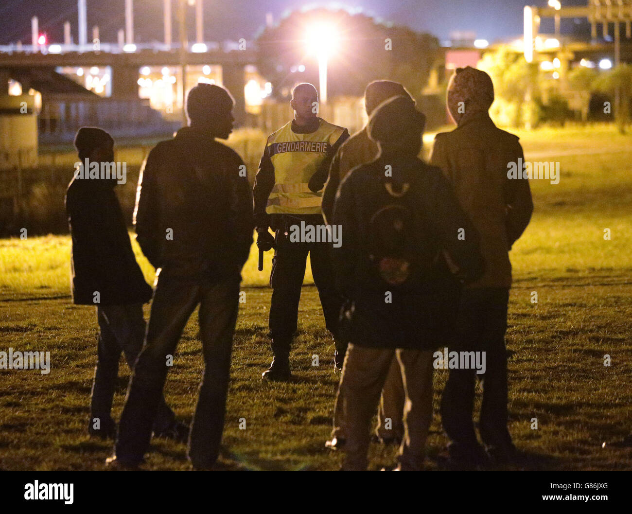 Gendarmerie Nazionale Francese vigilate sui migranti intorno alla recinzione perimetrale di sicurezza del sito Eurotunnel a Coquelles a Calais, Francia. Foto Stock