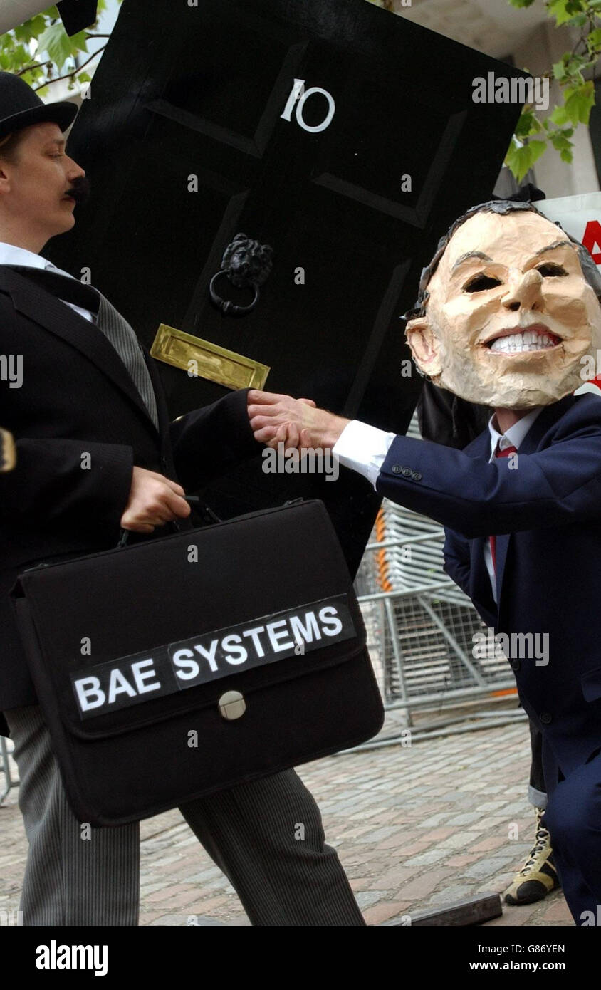I manifestanti vestiti da Tony Blair (a destra) e un uomo d'affari si incontrano all'esterno di una porta numero 10 Downing Street, all'Assemblea generale annuale della BAE, per protestare per il coinvolgimento del governo nel commercio di armi. Foto Stock