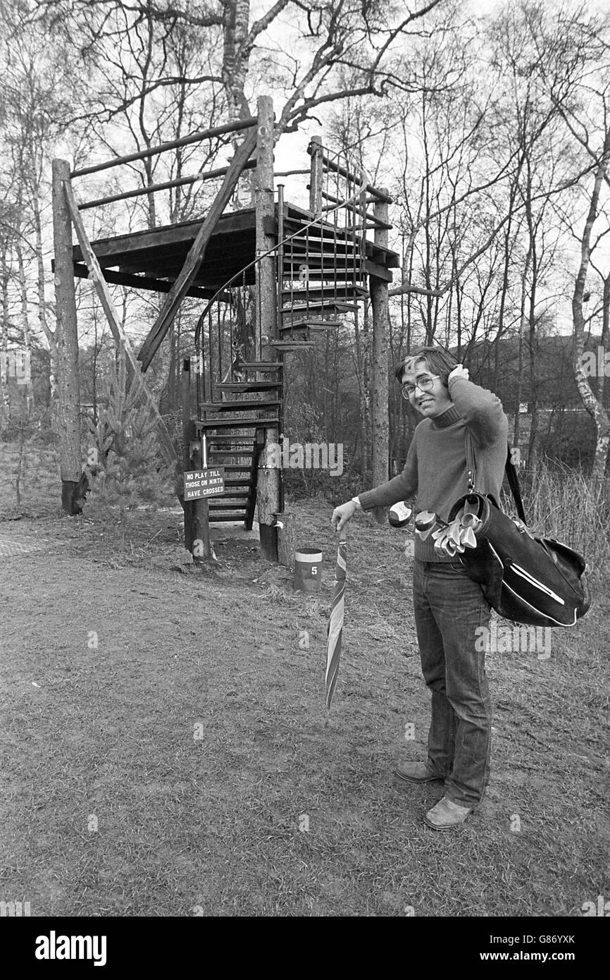 Un golfista bemused arriva al quinto tee sopraelevato, che consiste di una piattaforma di legno accessibile da una scala a chiocciola Foto Stock