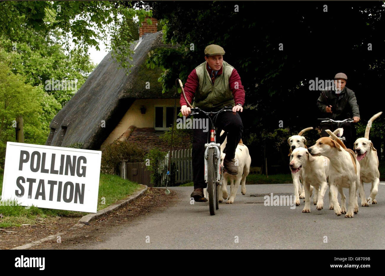 Gerald Sumner (a sinistra) e Kerry Thomas dalla Puckeridge Hunt prendono un pacchetto di hounds alla stazione di polling. Foto Stock