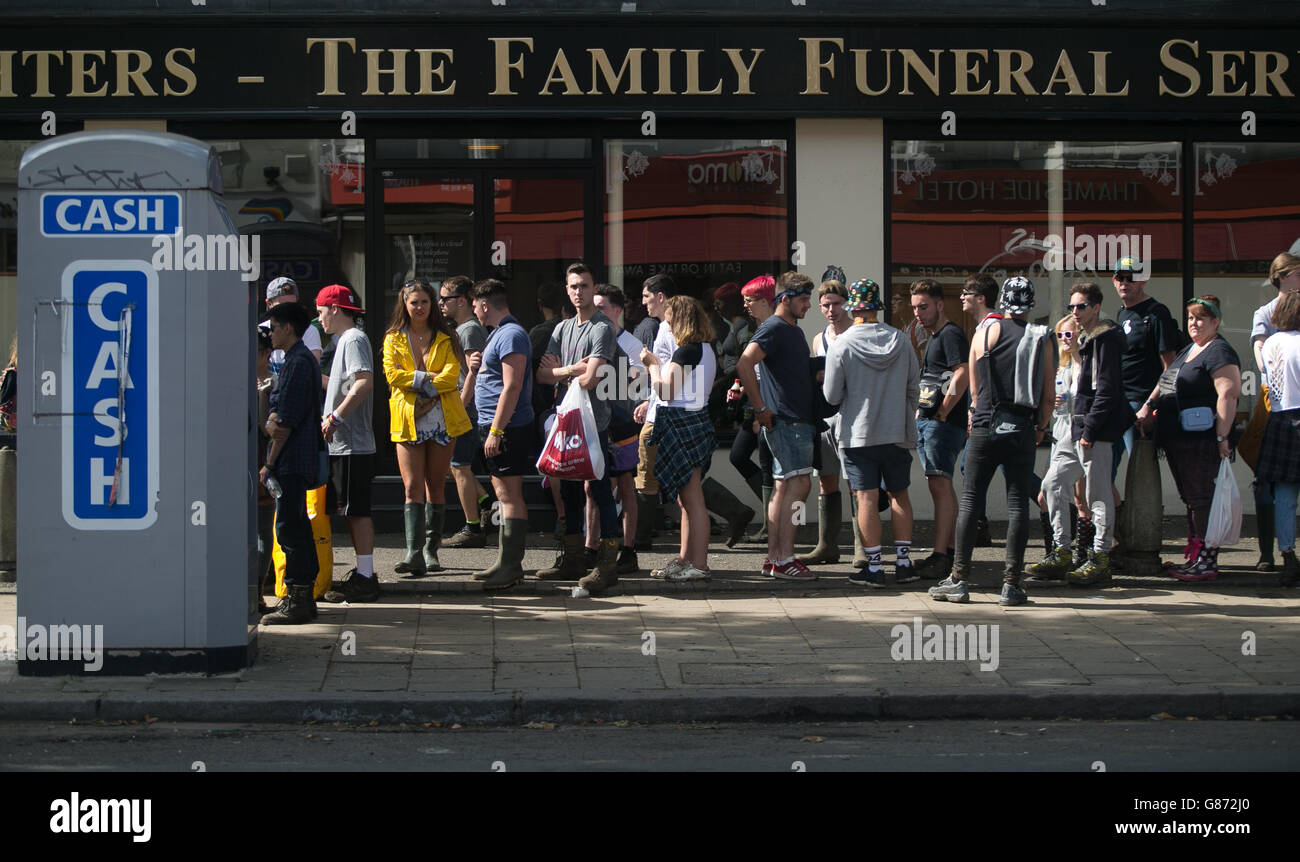 Gli amanti del festival aspettano di fronte a un bancomat vicino al Reading Festival, Berkshire. Foto Stock