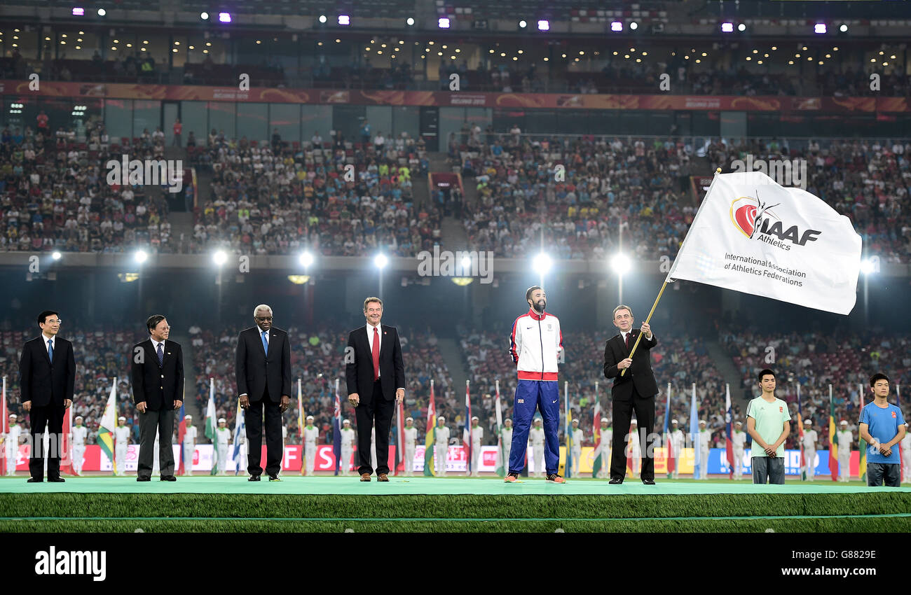 Simon Cooper, responsabile dello sport, ufficio del sindaco presso la Greater London Authority sventola la bandiera IAAF come capitano della Gran Bretagna Martyn Rooney (seconda a destra), presidente britannico di atletica Lynn Davies (centro), presidente uscente della IAAF Lamine Diack (terza a sinistra) E il sindaco di Pechino Wang Anshun (a sinistra) guarda avanti durante il giorno nove dei Campionati Mondiali IAAF allo Stadio Nazionale di Pechino, Cina. Foto Stock