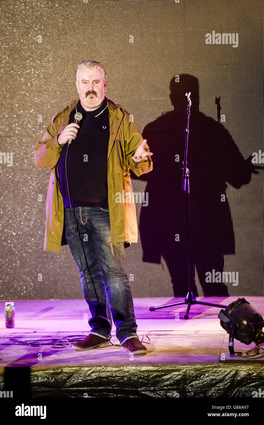 Il comico Mick Ferry suona durante una serata di commedia al parco a tema Banksy's Dismaland a Weston-super-Mare. Foto Stock