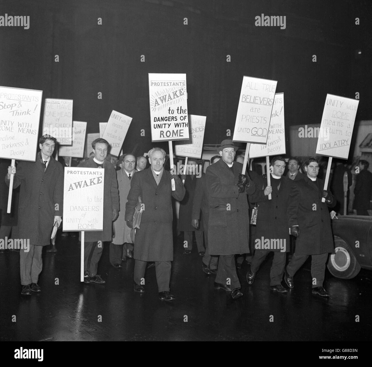 Il reverendo Ian Paisley (terzo da destra) si unisce a 22 membri dell'organizzazione del Consiglio Internazionale delle Chiese Cristiane, mentre hanno tenuto una marcia di protesta fuori dall'Abbazia di Westminster, Londra, in un momento in cui all'interno si stava svolgendo un servizio di unità della Chiesa. I banner hanno esortato i protestanti a 'svegliarsi ai pericoli dell'unità con Roma'. Foto Stock