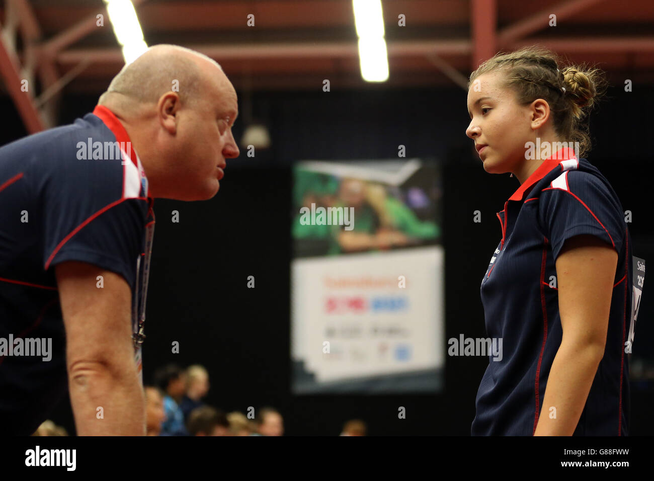 Denise Payet del Sud Est dell'Inghilterra parla con la sua allenatore durante il ping pong il giorno 2 dei Giochi scolastici 2015 di Sainsbury al Regional Tennis Center di Manchester. Foto Stock