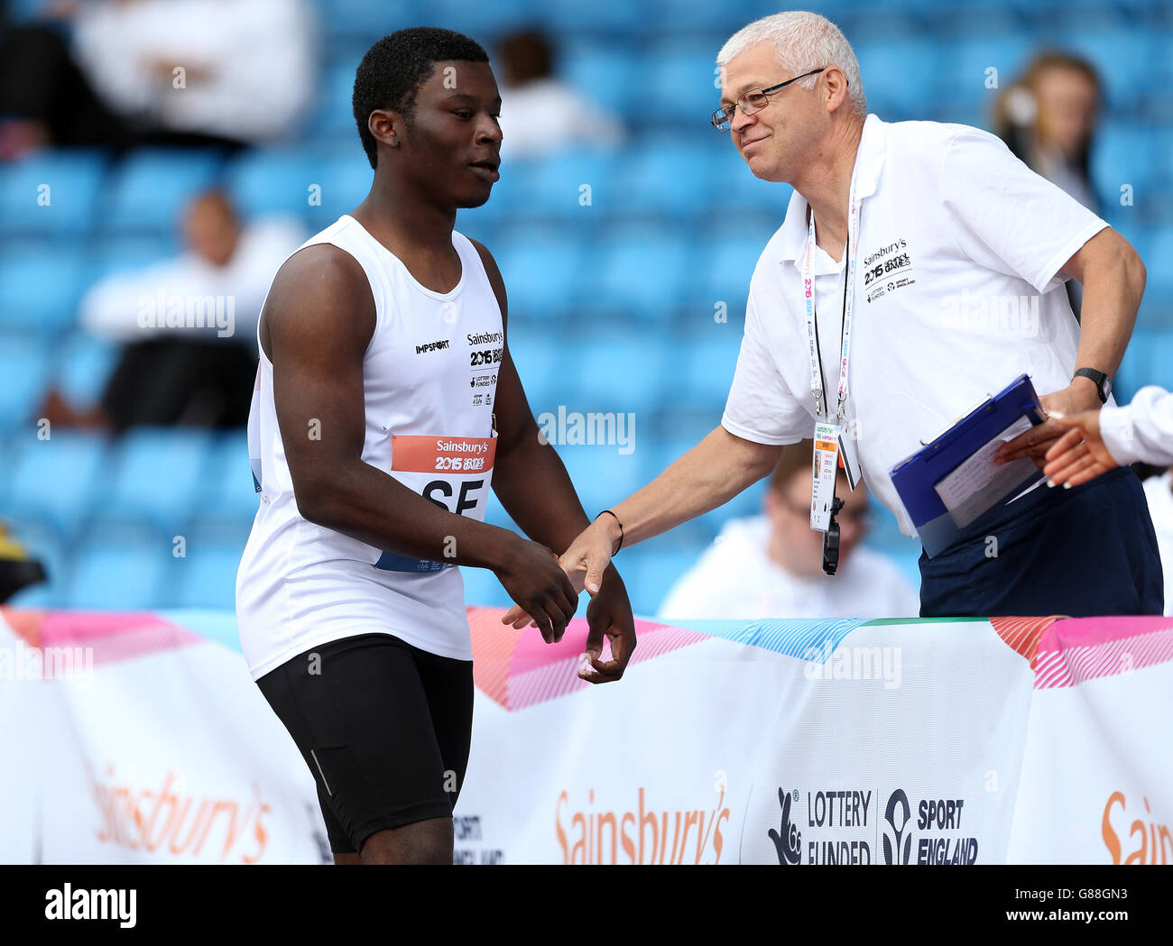 Inghilterra South East's Campon Lytle celebra la vittoria dei ragazzi 100 metri con il suo allenatore ai Sainsbury's 2015 School Games presso la Manchester Regional Arena. Foto Stock
