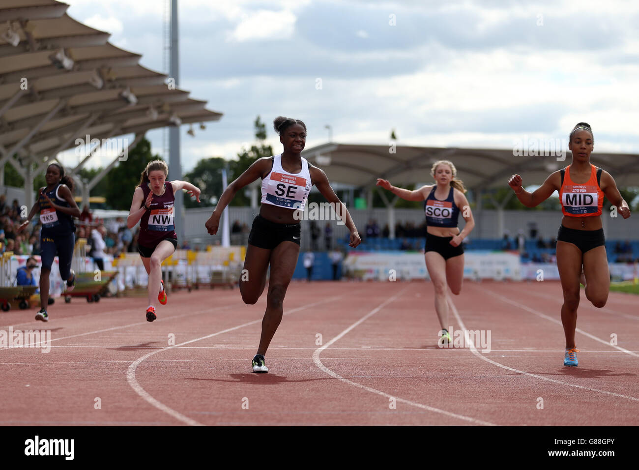 Inghilterra South East's Charmont Webster-Tape celebra la vittoria delle ragazze a 100 metri mentre attraversa la linea ai Sainsbury's 2015 School Games alla Manchester Regional Arena. Foto Stock