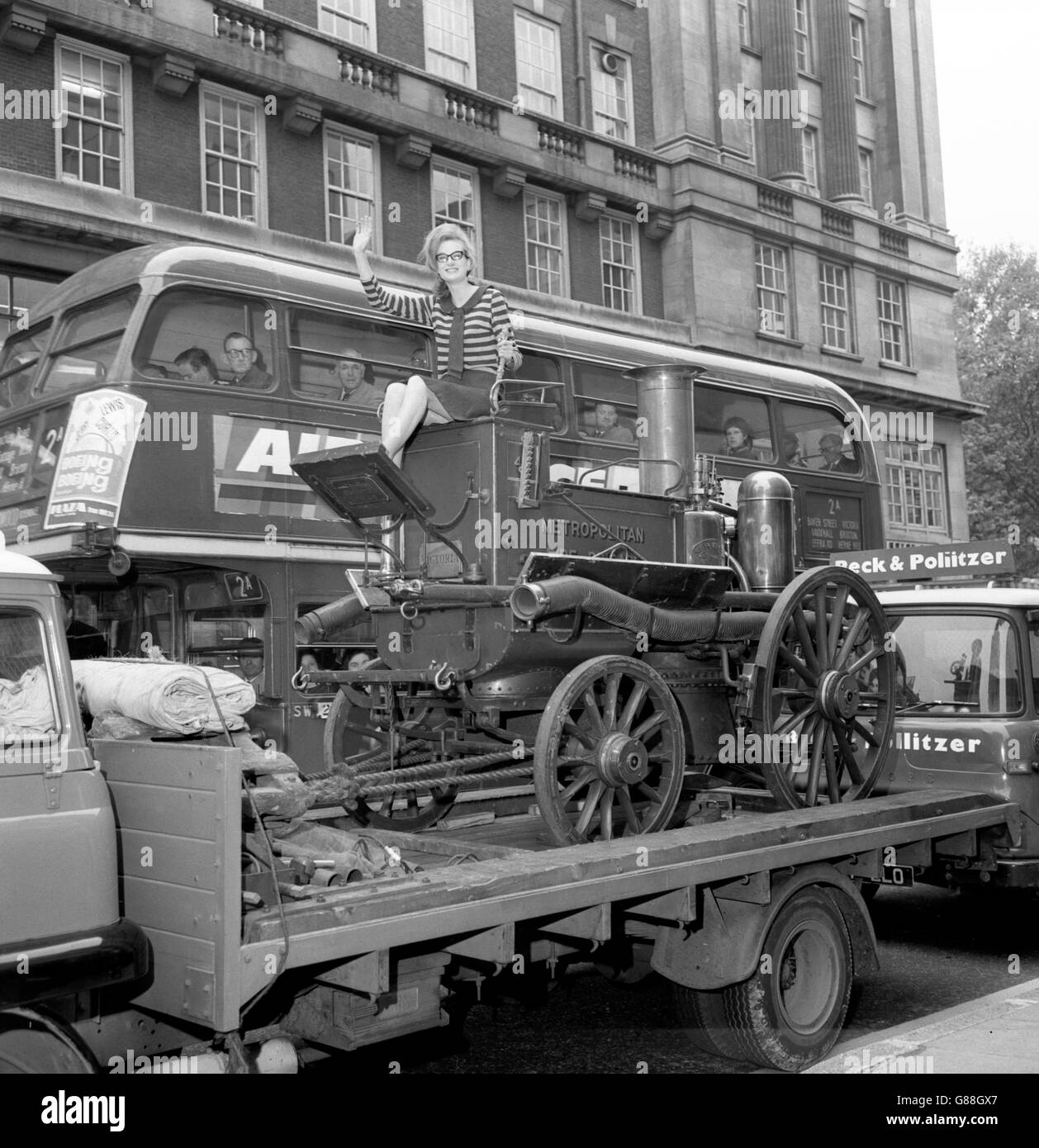 Ci sono state delle perle di ammirazione da parte degli spettatori sui ponti superiori degli autobus al motore antincendio d'epoca in Orchard Street, Londra. Il motore antincendio è stato prodotto nel 1880 e si chiama Victoria. Così è stato naturale Victoria Feren, un dipendente di Selfridges, dovrebbe provare il sedile del conducente quando ha accolto il suo posto al negozio di Londra, dove sarà in mostra in una speciale Centenary Exhibition del London Fire Brigade. Foto Stock