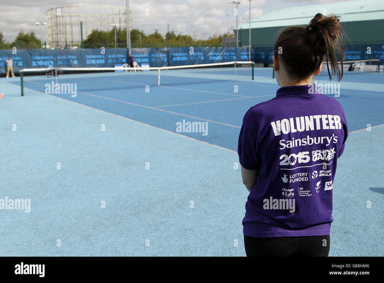 Un volontario sorveglia il tennis su sedia a rotelle ai Giochi scolastici Sainsbury's 2015 presso il Regional Tennis Center di Manchester. Foto Stock