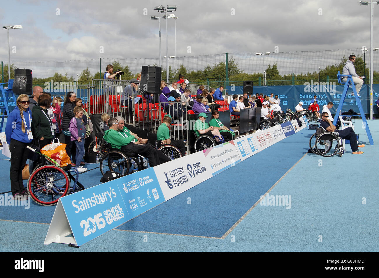 Gli spettatori guardano il tennis su sedia a rotelle ai Giochi scolastici Sainsbury's 2015 presso il Regional Tennis Center di Manchester. Foto Stock
