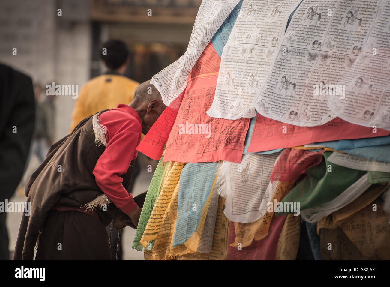 LHASA, IN TIBET - Maggio 2016 - Una donna prega nella parte anteriore del Jokhang Tempio Foto Stock