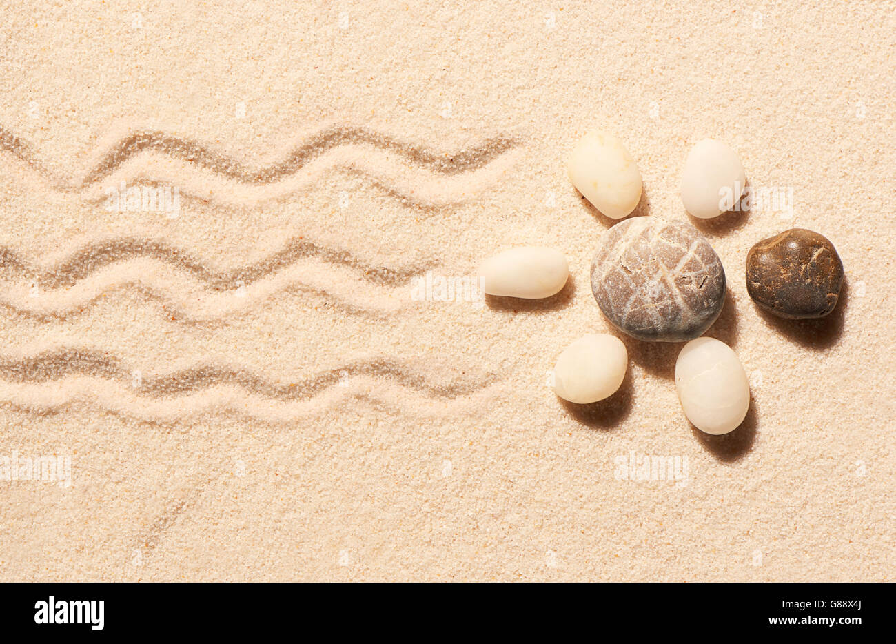Turtle fatta di pietre di mare con segni di coda e le gambe sulla sabbia. Estate spiaggia sfondo. Vista da sopra Foto Stock