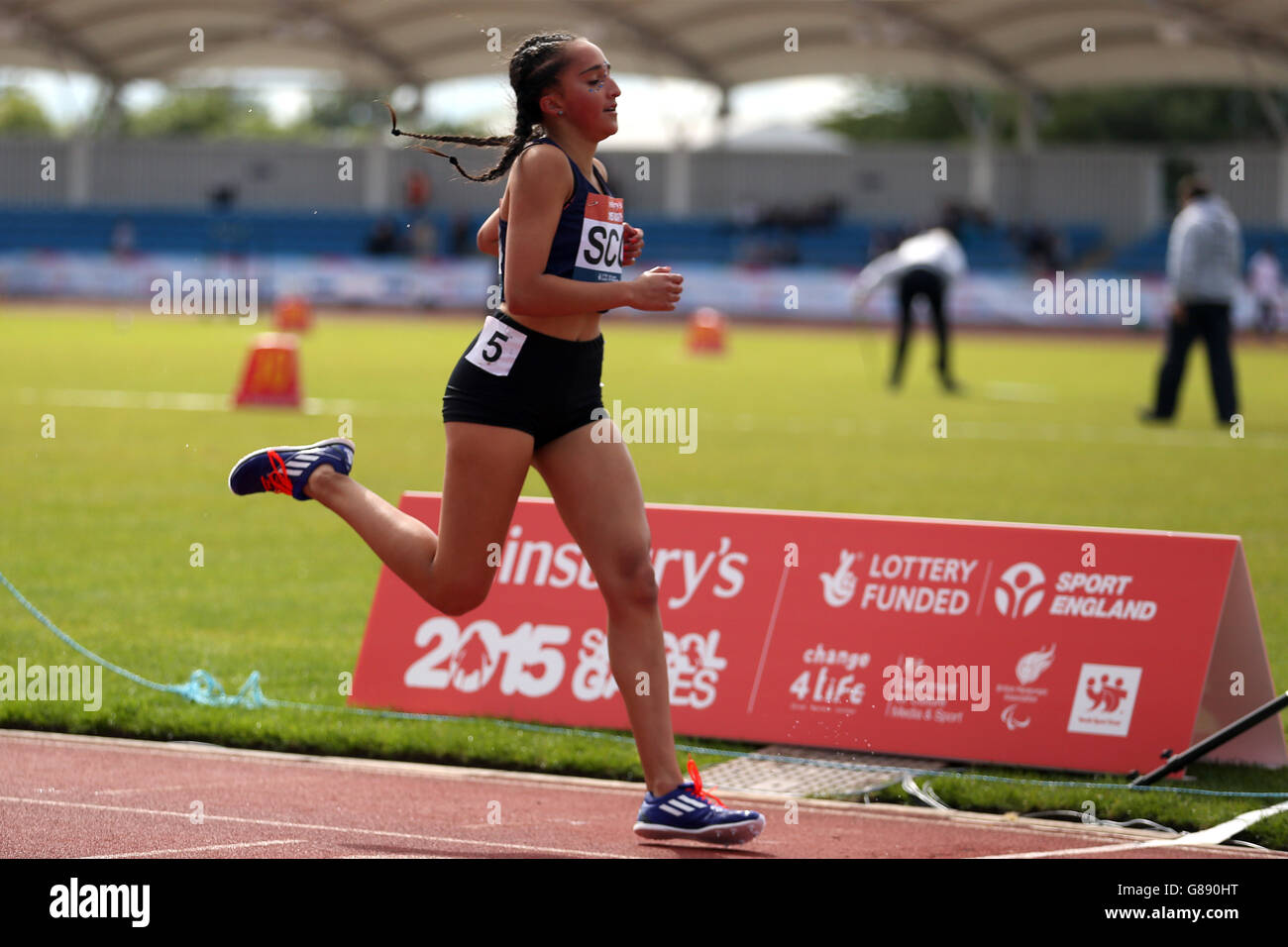 Zaynah Aziz, scozzese, attraversa la linea in una steeplechase di 1500 m per le ragazze alla Sainsbury's 2015 School Games presso la Manchester Regional Arena. Foto Stock