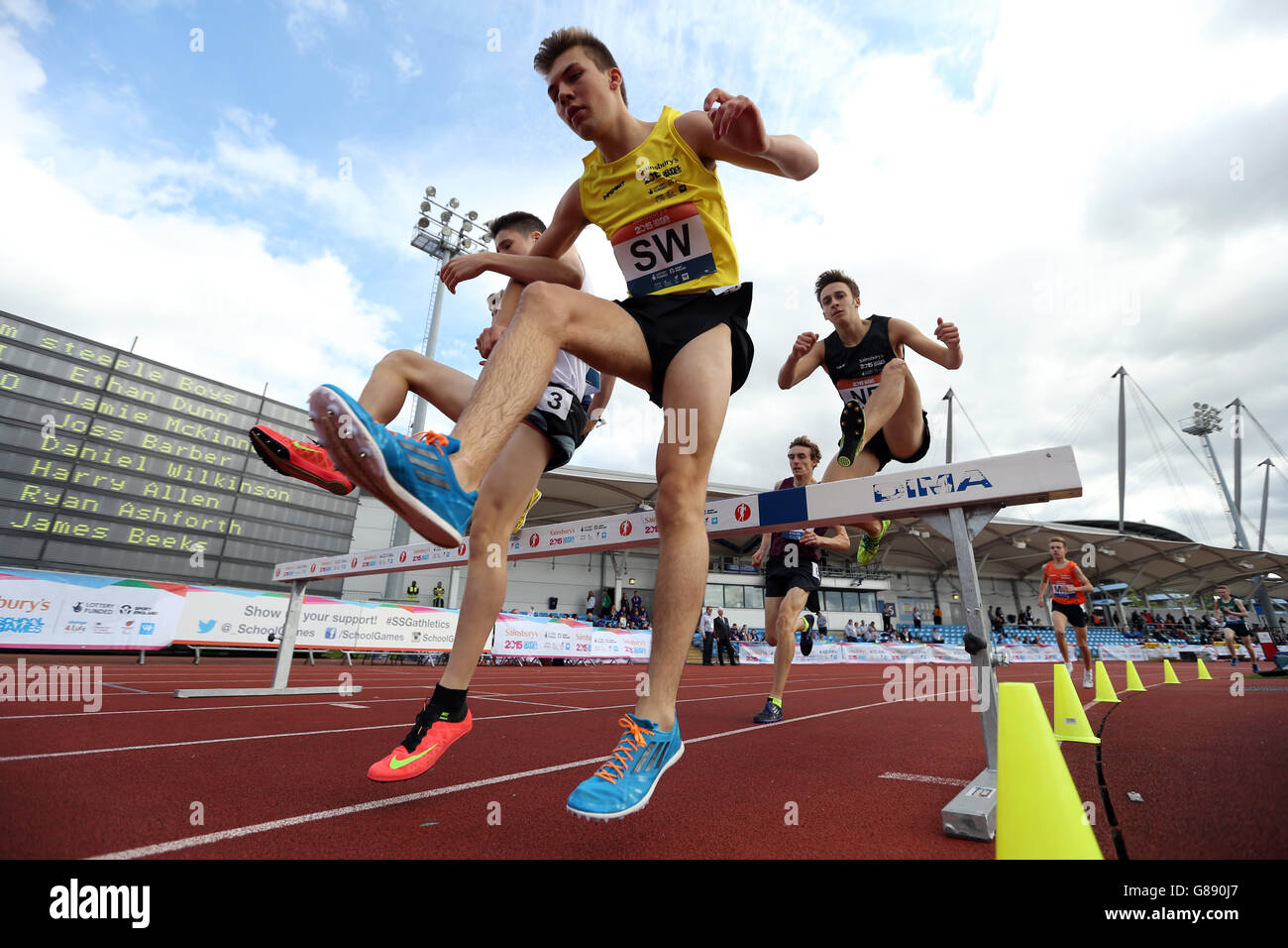 James Beek del South West dell'Inghilterra salta un ostacolo durante i ragazzi 1500m steeplechase ai Sainsbury's 2015 School Games presso la Manchester Regional Arena. Foto Stock