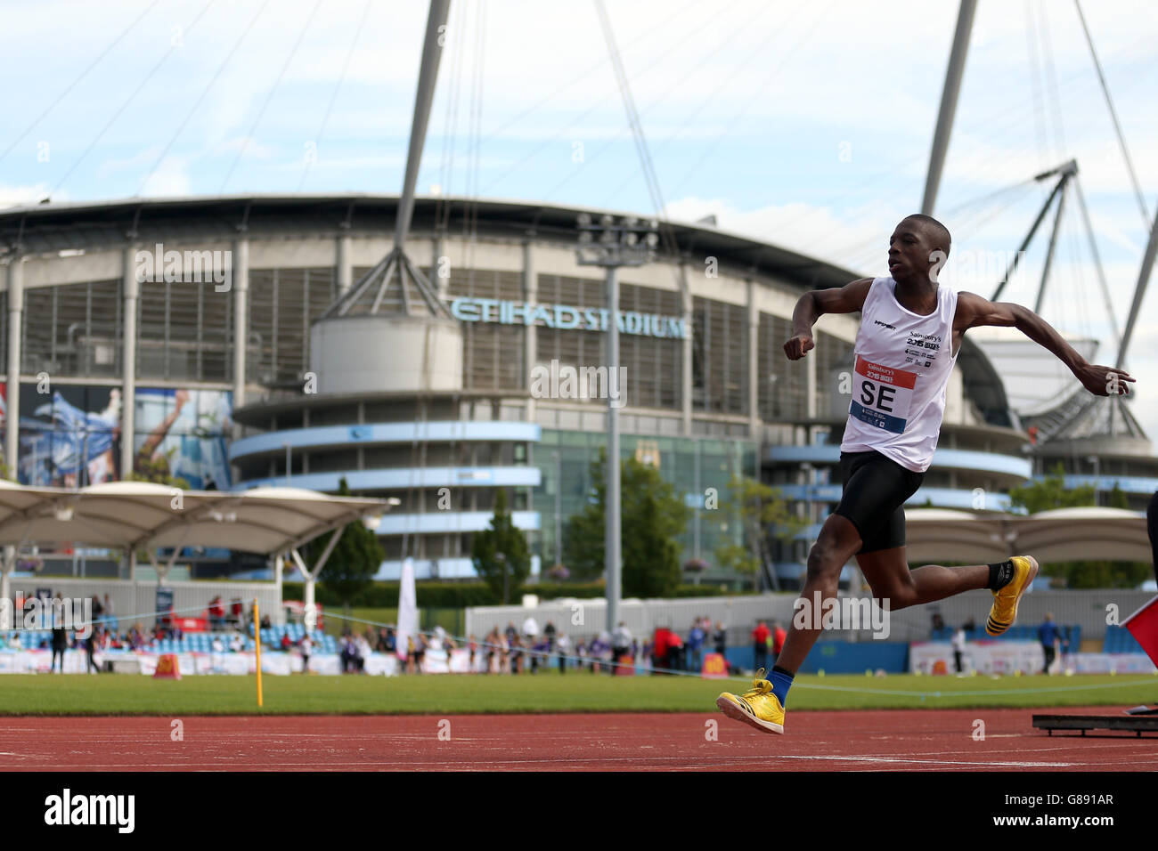 Inghilterra la Jude Bright-Davies del Sud Est partecipa al triplice salto dei ragazzi presso i Sainsbury's 2015 School Games alla Manchester Regional Arena. Foto Stock
