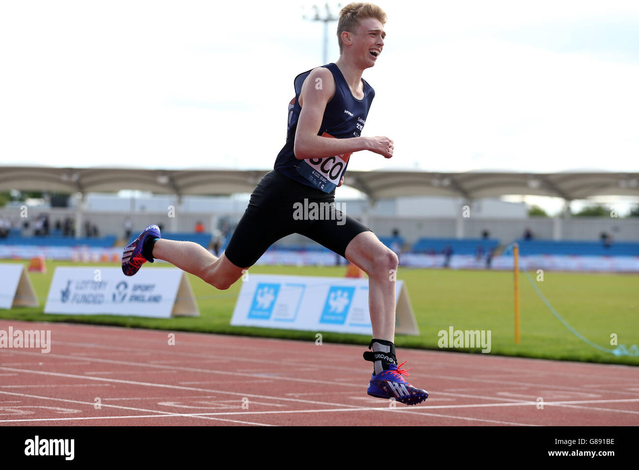 Iain Boyd della Scozia attraversa il traguardo durante i 200 m di ambulante presso i Sainsbury's 2015 School Games alla Manchester Regional Arena. Foto Stock