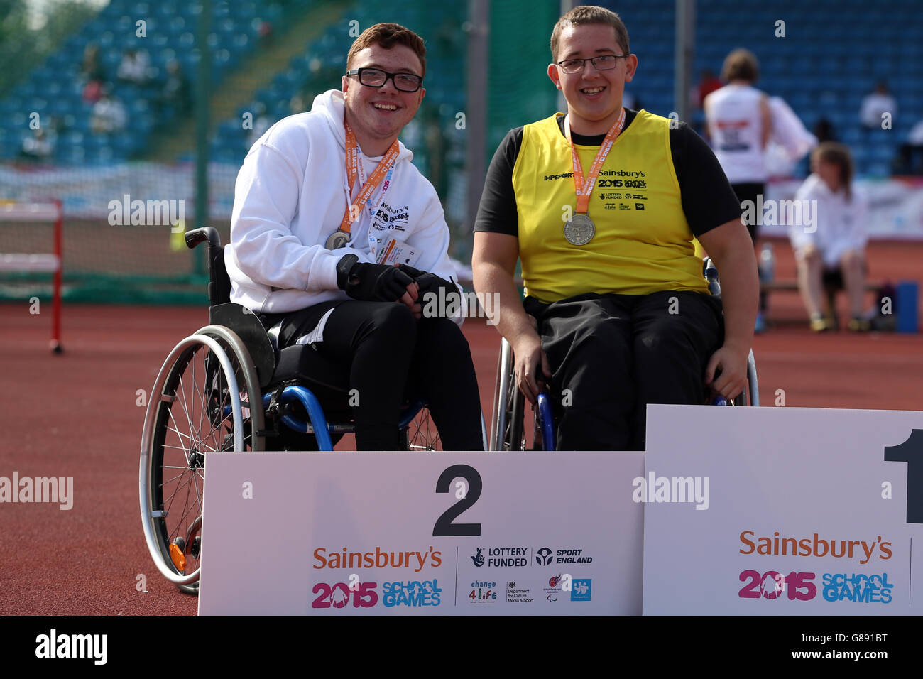 (l-r) Inghilterra George Barnard del sud-est e Gareth Picken dell'Inghilterra del sud-ovest ricevono i loro ragazzi con le medaglie discali seduti durante la cerimonia delle medaglie ai Giochi scolastici 2015 di Sainsbury alla Manchester Regional Arena. Foto Stock