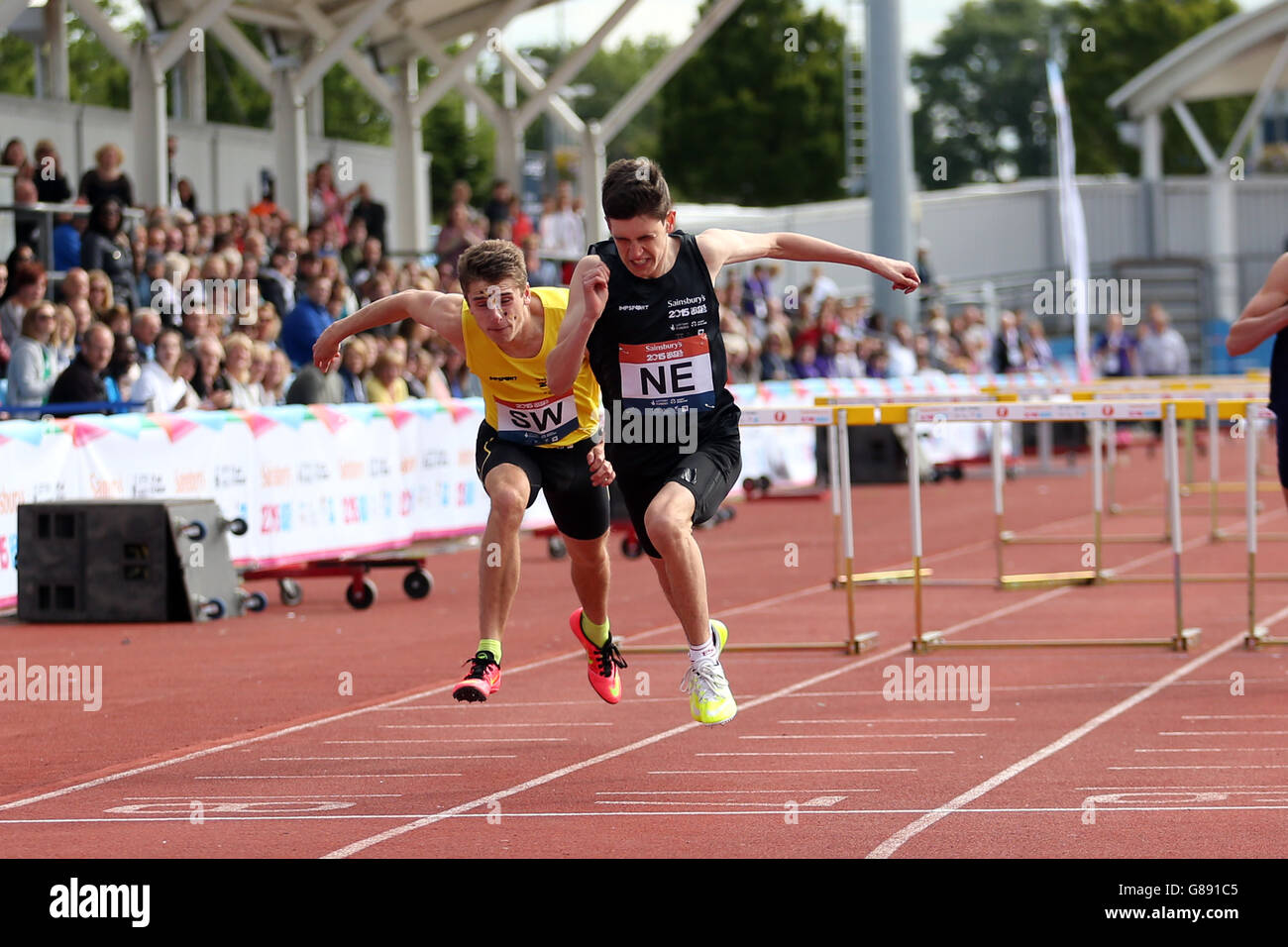 Inghilterra il Nicholson di Jason Nord Est attraversa la linea per vincere i ragazzi a 100 m ostacoli ai Sainsbury's 2015 School Games alla Manchester Regional Arena. Foto Stock