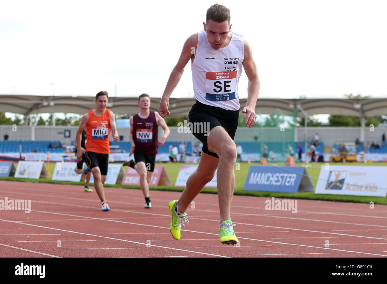 Inghilterra il South East's Kyle Powell attraversa il traguardo per vincere i ragazzi ambulanti 200 m ai Sainsbury's 2015 School Games presso la Manchester Regional Arena. Foto Stock