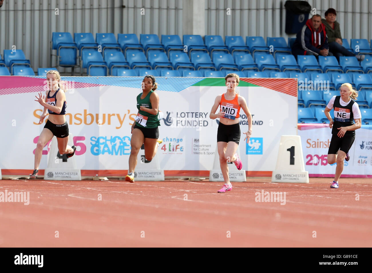 Gli atleti partecipano all'evento ragazze ambulanti 200m al Sainsbury's School Games 2015 della Manchester Regional Arena. Foto Stock
