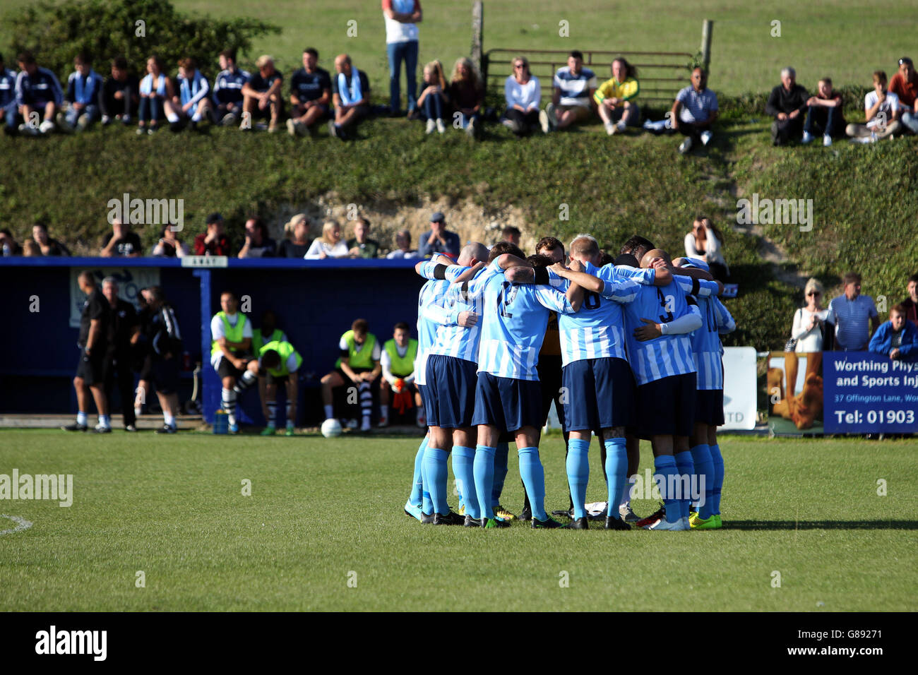 Il team del Worthing United FC si è accovacciato prima di iniziare la partita fa Vase contro l'East Preston FC in Worthing Sussex, il primo gioco che Worthing ha giocato da due giocatori di Worthing United, Jacob Schilt e Matthew Grimstone, ha tragicamente perso la vita nel disastro di Shoreham. Foto Stock