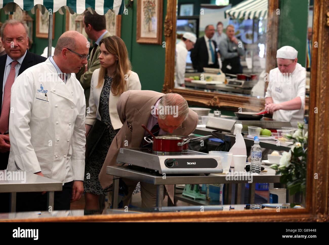 Il Principe del Galles, conosciuto come il Duca di Rothesay quando in Scozia, sniffs una vaschetta di alimento mentre incontra gli allievi di cucina dall'Ayrshire College durante un evento alla casa di Dumfries per celebrare i prodotti di Ayrshire ospitati come parte dell'anno 2015 della Scozia di alimento e bevanda. Foto Stock