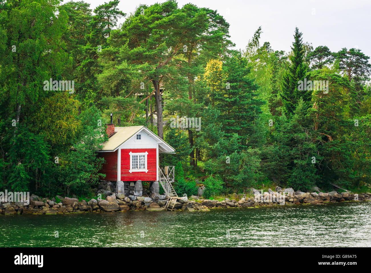 Rosso di legno finlandese Sauna Log Cabin sull isola in estate Foto Stock