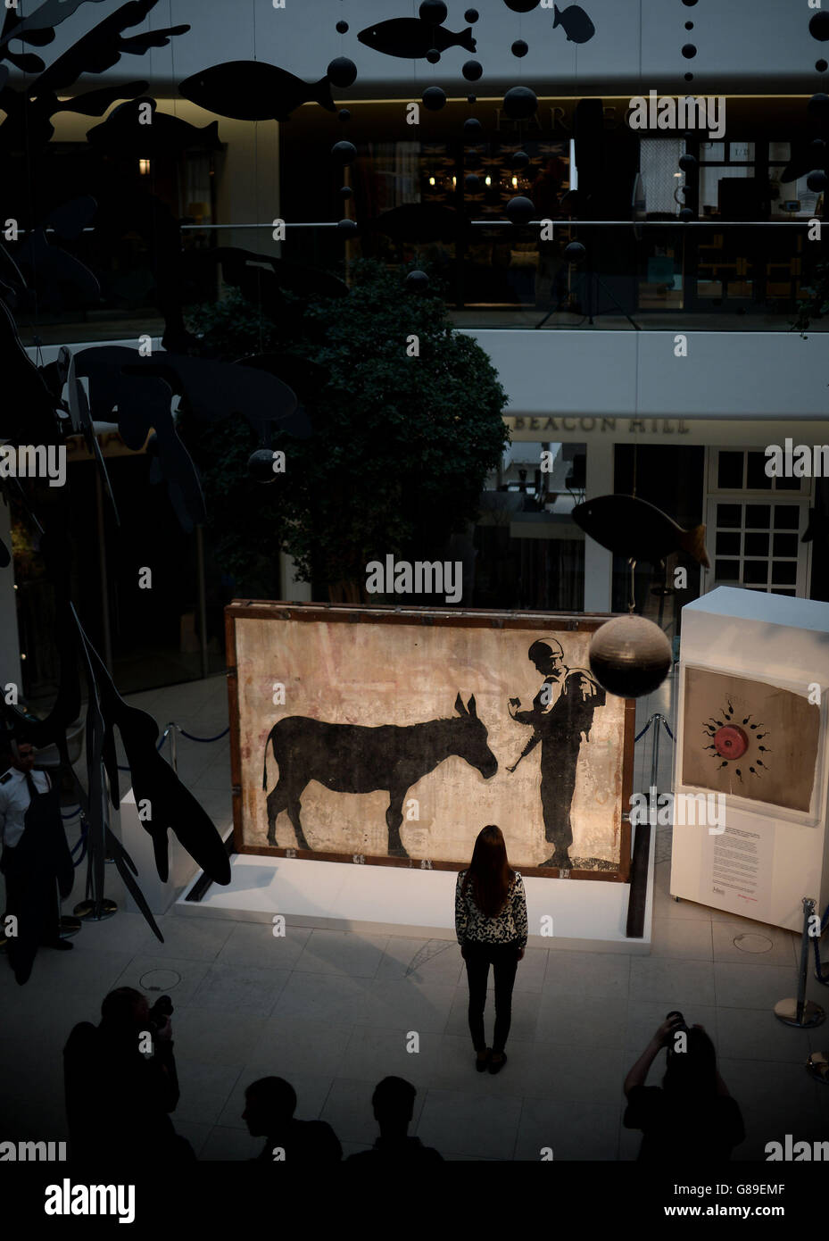 Una donna vede il 'Donkey Documents' di Banksy, un murale intatto di quattro tonnellate da Gerusalemme, nel Design Center a Chelsea, Londra. Foto Stock