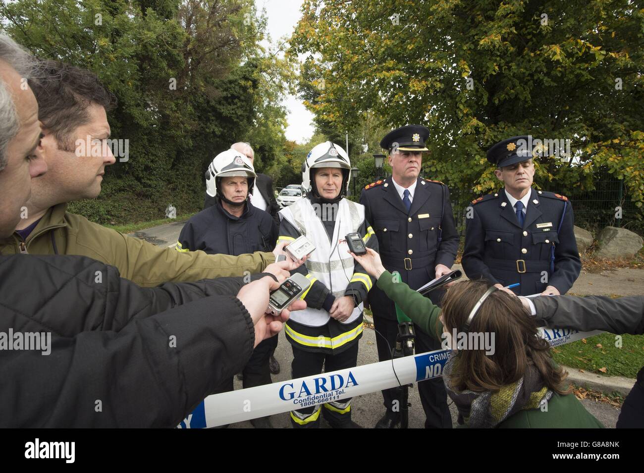 Gerry Stanley, Dennis Keeley, assistente capo fire officer Dublin City Vigili del Fuoco, sovrintendente Diarmuid O'Sullivan e Martin Fitzgerald parlare con il supporto vicino alla scena di Carrickmines, a sud di Dublino dove nove persone si ritiene che hanno perso la vita in un incendio in un sito di viaggiatore. Foto Stock