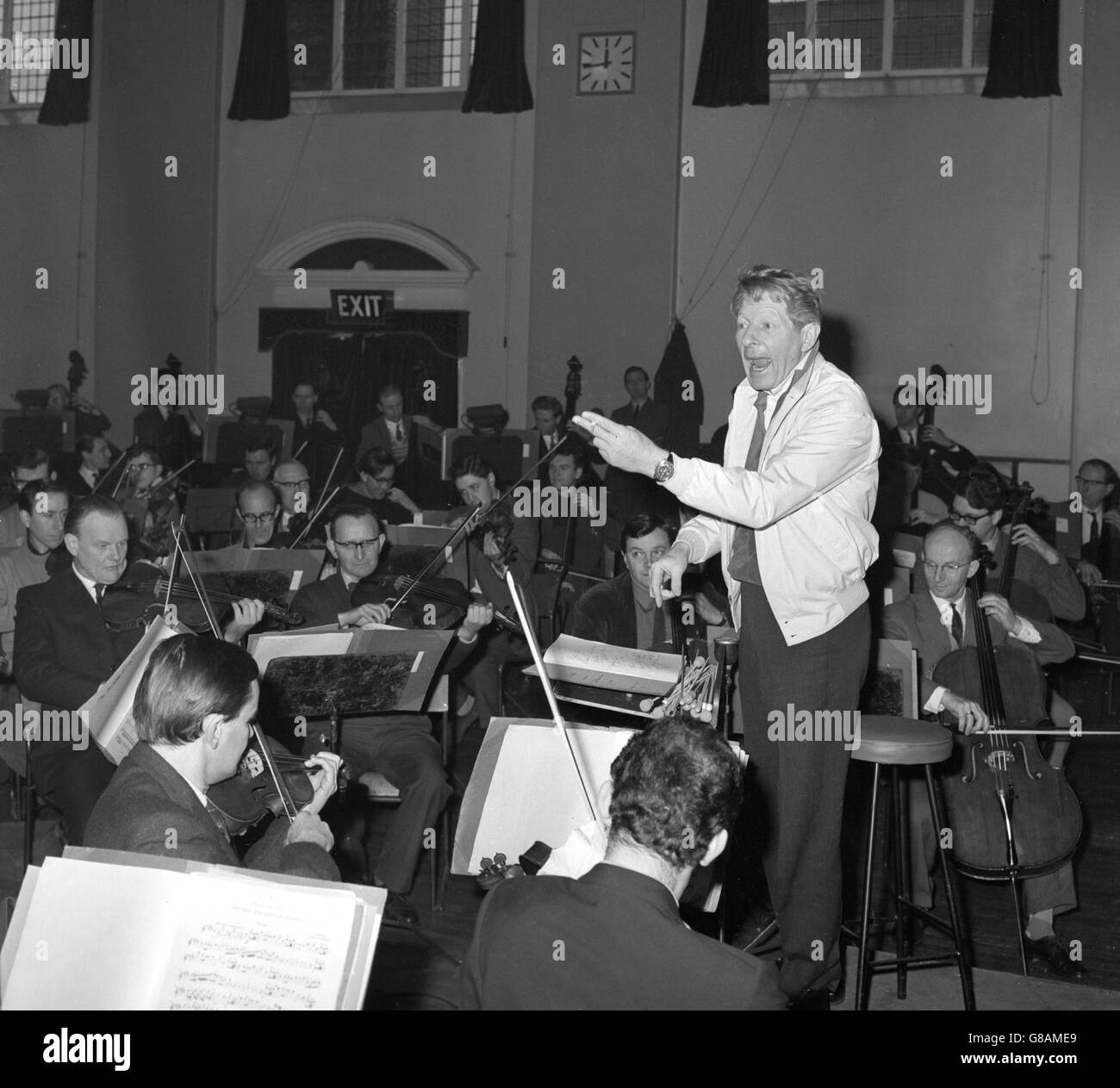 Danny Kaye conduce una prova della London Philharmonic Orchestra al Battersea Town Hall di Londra. Egli condurrà l'orchestra al concerto LPO appeal fund presso la Royal Albert Hall domani sera. Foto Stock