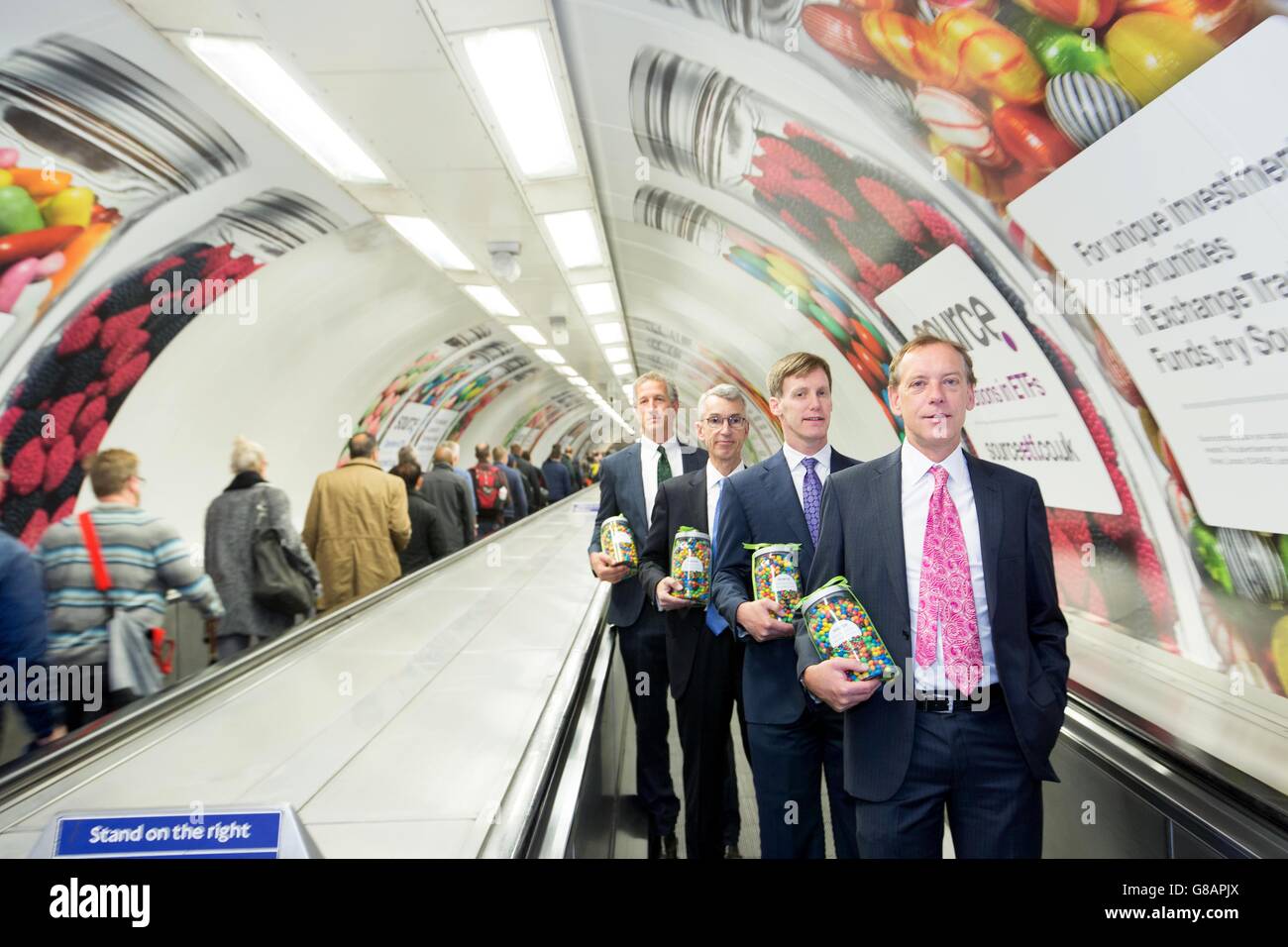 (Da sinistra) Peter Thompson presidente, James Polisson Chief Marketing Officer, Mike Paul Vice President e Lee Kranefuss Executive Chairman Source, lanciano l'ultima campagna del provider ETP con giare di dolci all'interno della Bank Underground Station, Londra, che rappresentano la trasparenza e la varietà del mercato ETP. Foto Stock