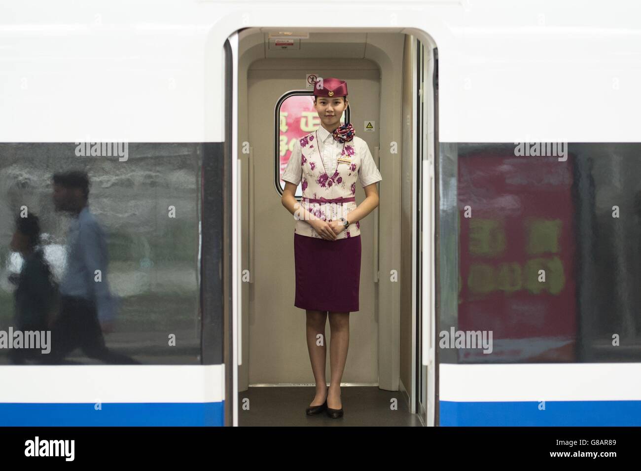 L'equipaggio su un treno ad alta velocità aspetta la partenza alla stazione ferroviaria di Chengdu Est, mentre il Cancelliere George Osborne ha fatto un giro della stazione dopo un incontro con gli investitori cinesi a Chengdu, Dove li ha esortati a fare un'offerta per una quota di &Acirc;&Pound;11.8 miliardi di contratti di ingegneria civile HS2 e &Acirc;&Pound;24 miliardi di sviluppi nelle città del Nord, prima di visitare la stazione. Foto Stock