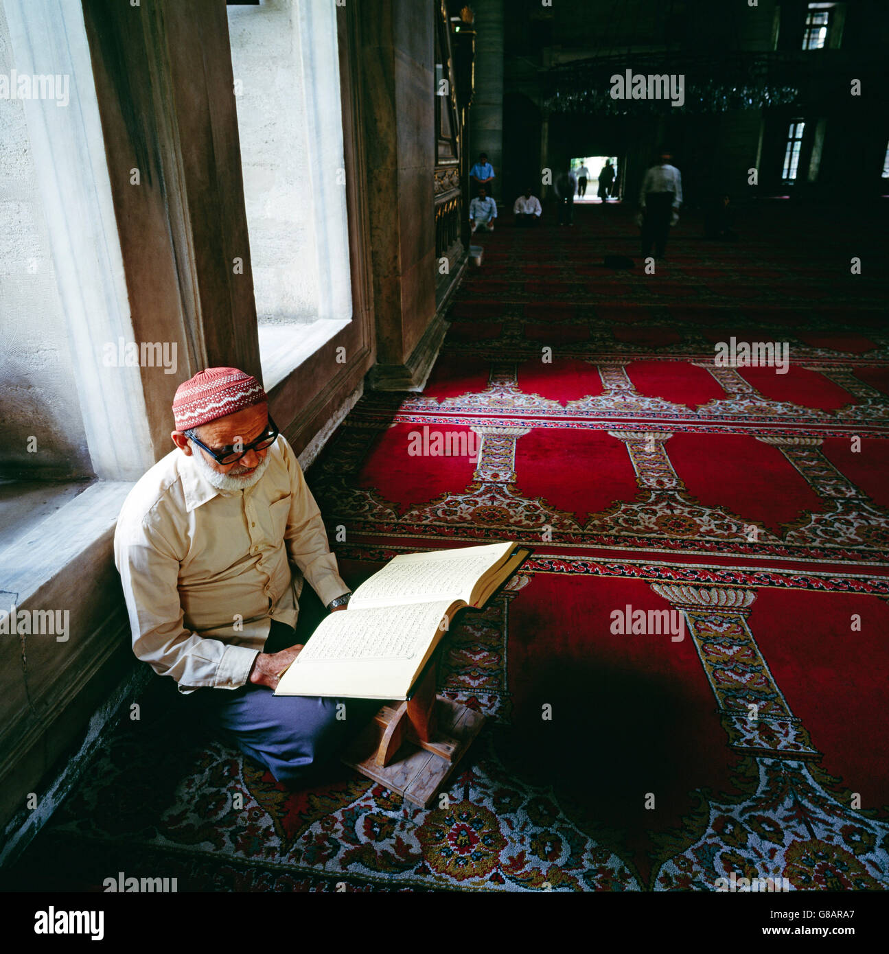 Il vecchio uomo la lettura del Corano alla Moschea Fatih, Istanbul, Turchia Foto Stock