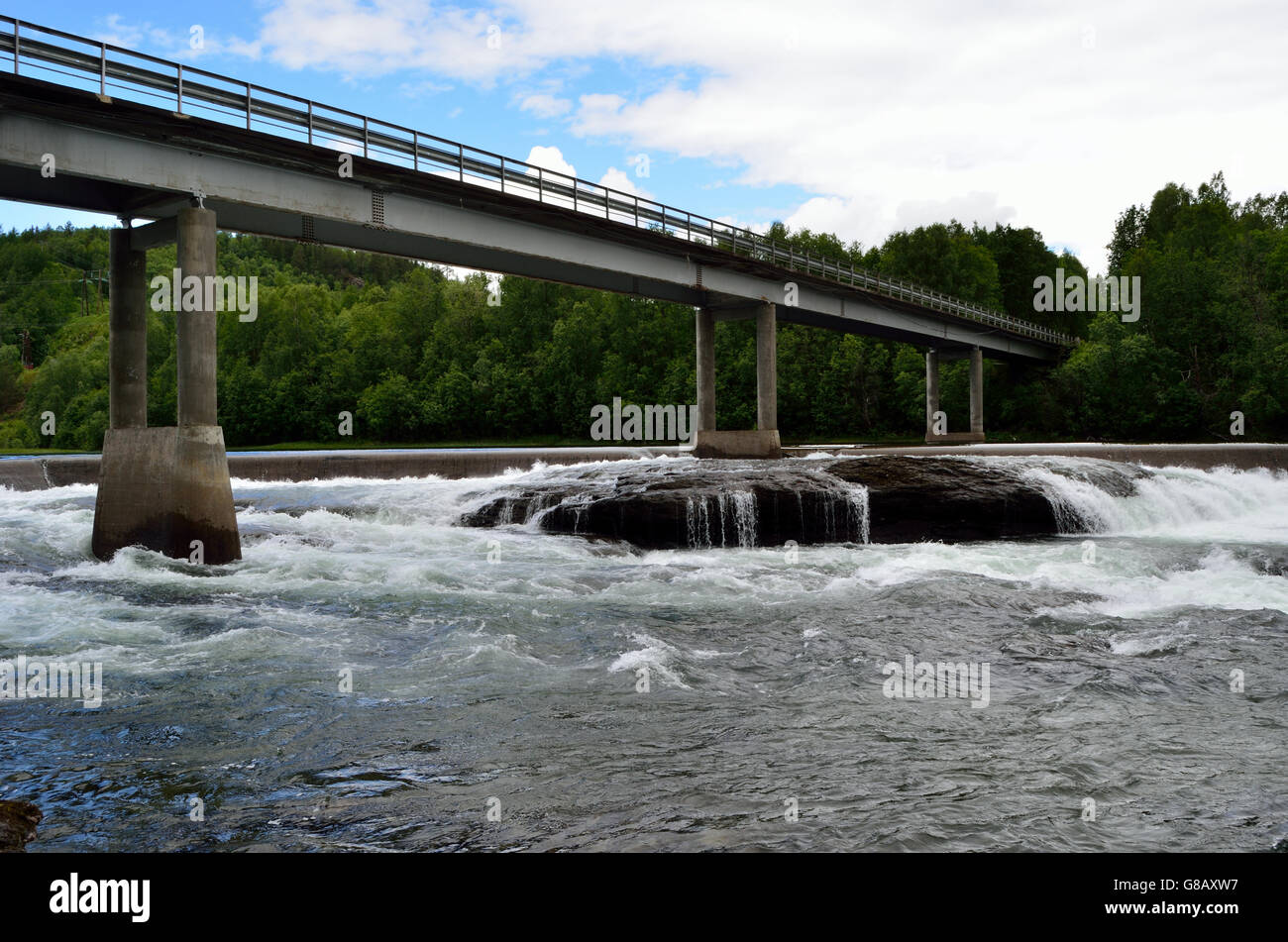 Ponte di cemento con un enorme flusso di acqua sotto in estate Foto Stock