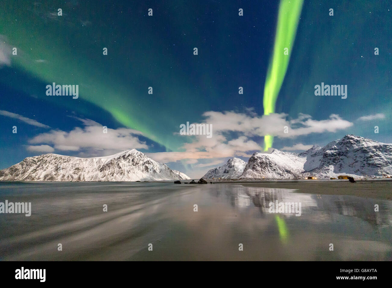 Luci del nord e le montagne si riflette nelle fredde acque Skagsanden Isole Lofoten Norvegia del Nord Europa Foto Stock