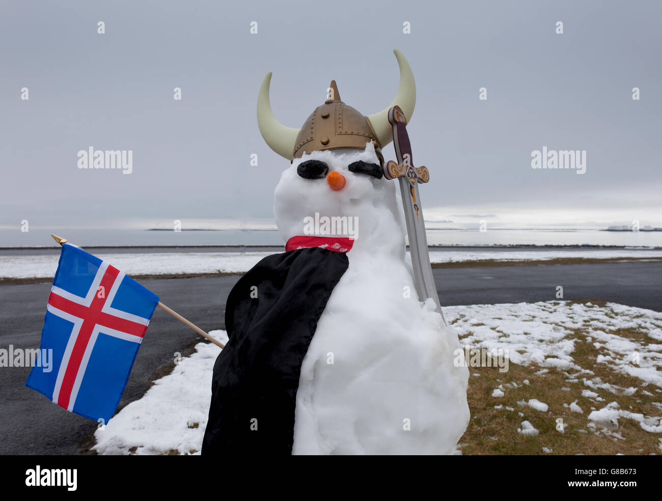 Pupazzo di neve vestito come un Vichingo con una bandiera islandese, Seltjarnarnes, Reykjavik, Islanda Foto Stock