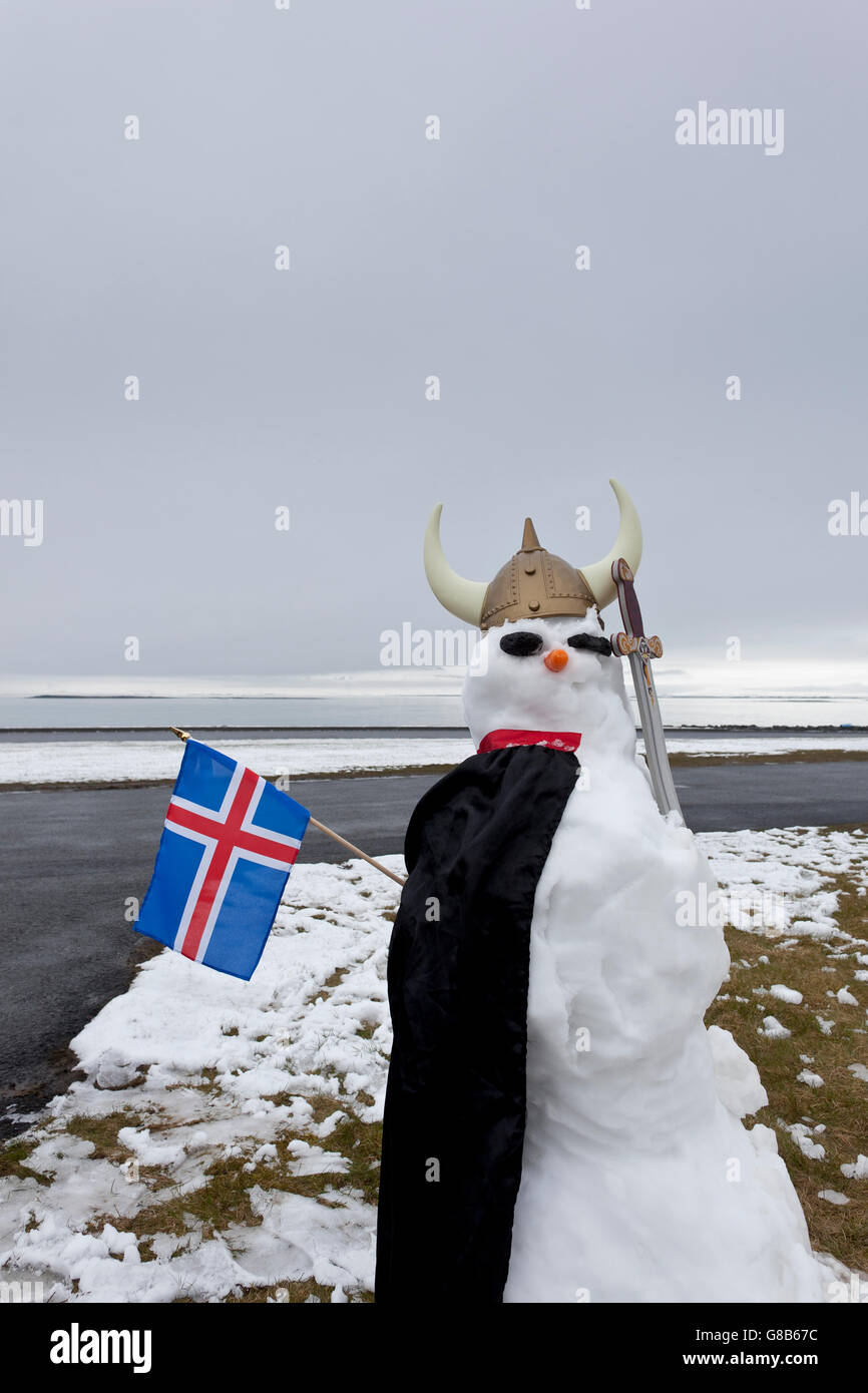 Pupazzo di neve vestito come un Vichingo con una bandiera islandese, Seltjarnarnes, Reykjavik, Islanda Foto Stock