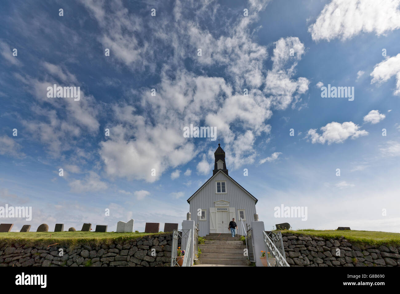 Tourist sui gradini della chiesa Strandakirkja, penisola di Reykjanes, Islanda Foto Stock