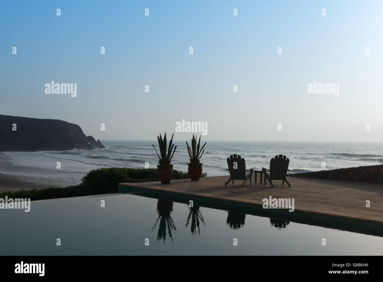 Due di legno sedie rilassanti accanto ad una piscina in spiaggia. Foto Stock