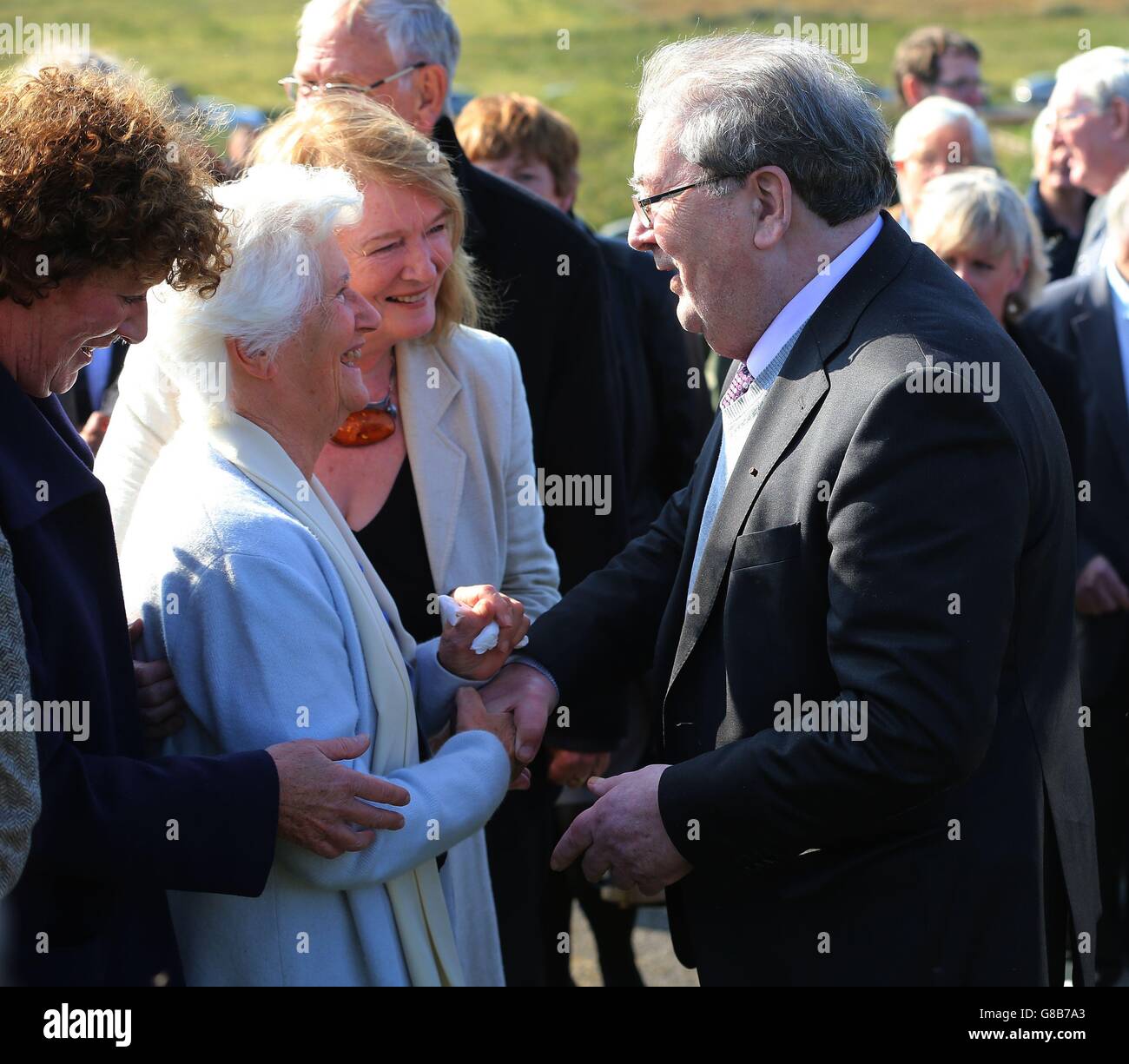 Anne, vedova di Brian Friel (seconda a sinistra), parla con l'ex leader della SDLP John Hume, durante il funerale del drammaturgo irlandese al Cimitero di Glenties in Co Donegal. Foto Stock