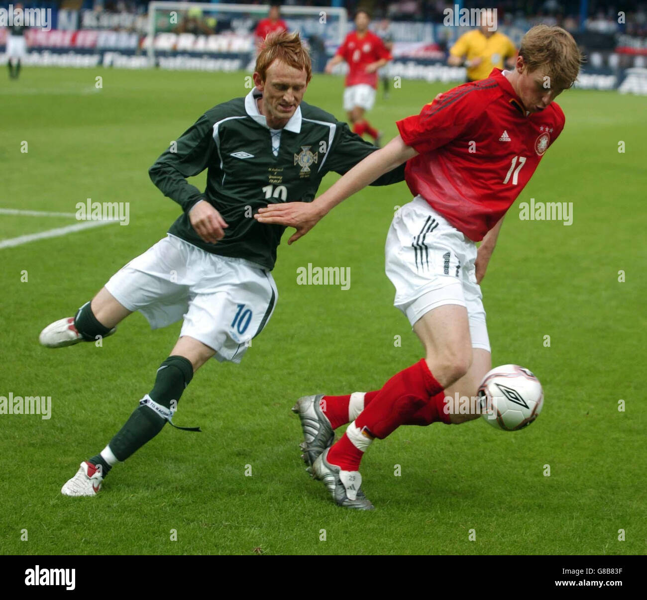 Steve Jones (L) dell'Irlanda del Nord mette sotto pressione la difesa della Germania. Foto Stock