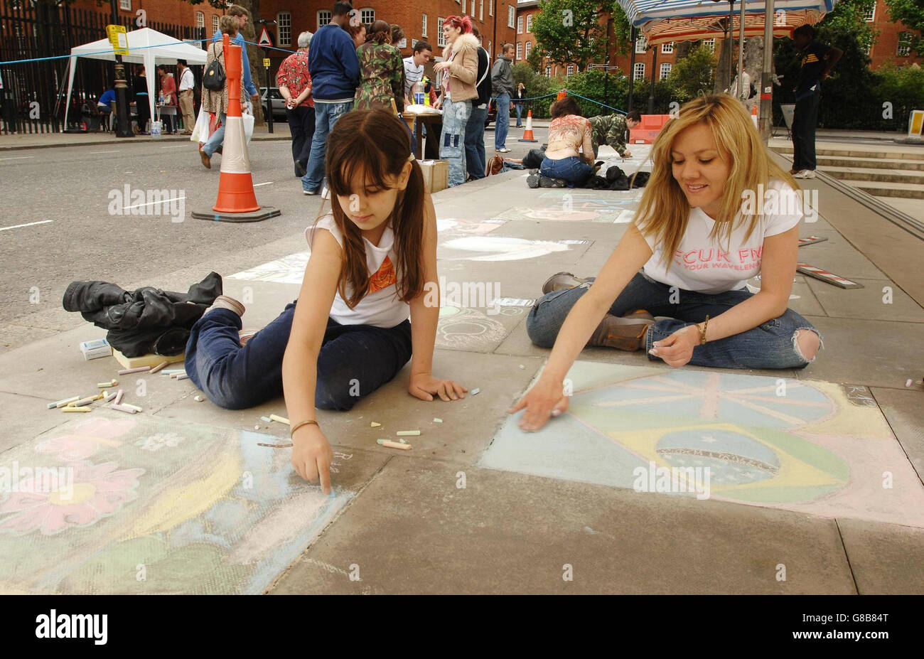 Val Schleiniger e la figlia Tamires, 9 anni, prendono parte alla creazione di una 'tela-treet' sul marciapiede fuori Tate Britain. Foto Stock